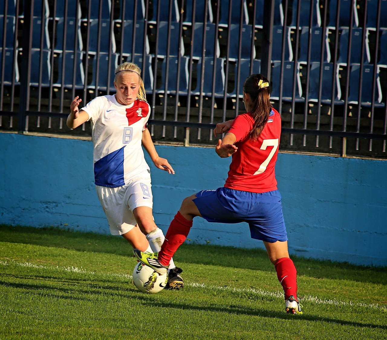 Dos futbolistas internacionales disputan un balón durante un partido de selecciones